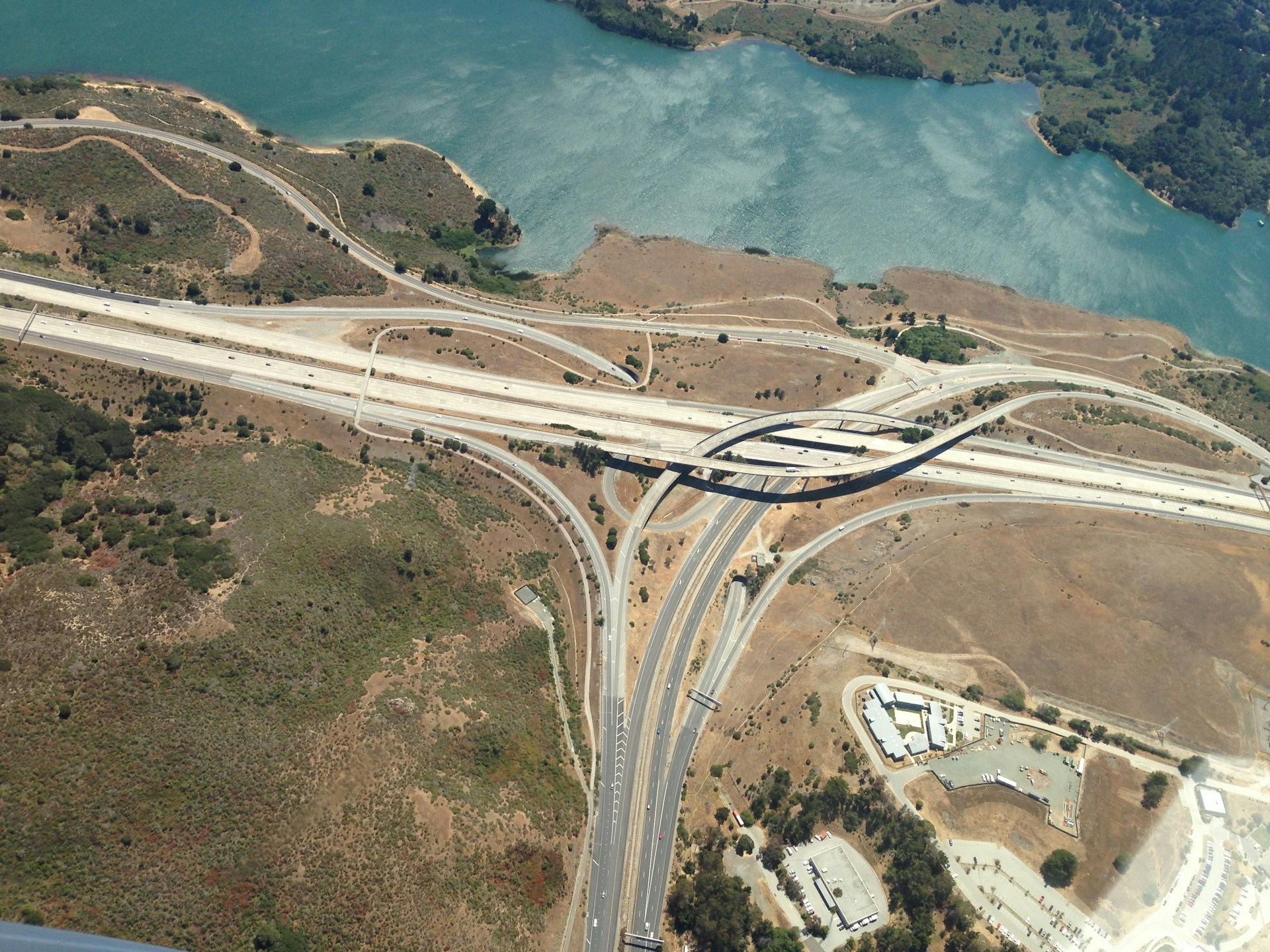An aerial view of a highway interchange beside a waterway in Belmont, California.